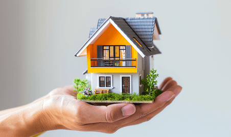 创意贷款房产在手里托住房子模型特写资产贷款房贷